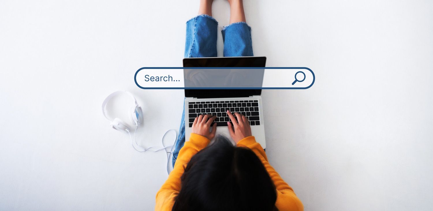 Lady with laptop on her knee searches the web